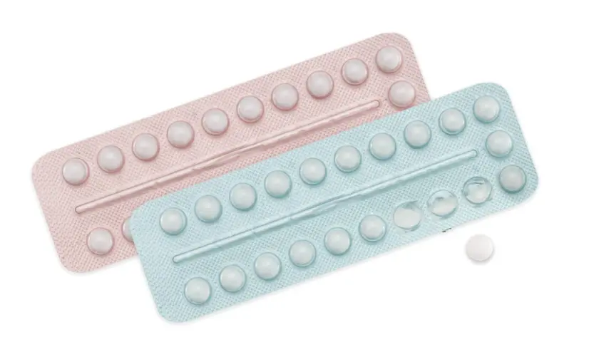 Dwie blistry tabletek antykoncepcyjnych, różowy i niebieski, z kilkoma brakującymi tabletkami.